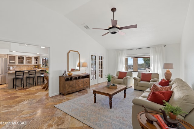 living room with high vaulted ceiling, french doors, stone finish floor, and a ceiling fan