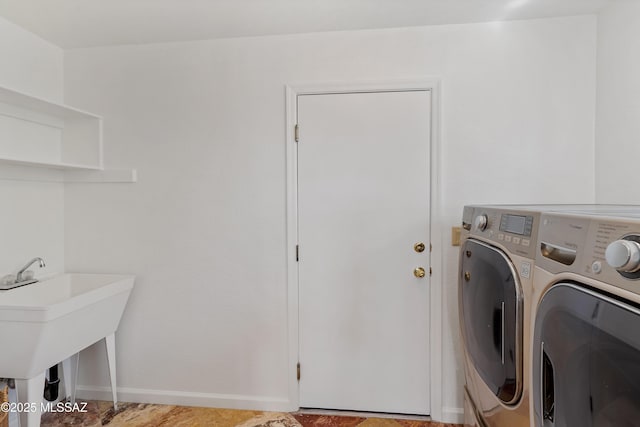 clothes washing area featuring laundry area, baseboards, and washer and dryer