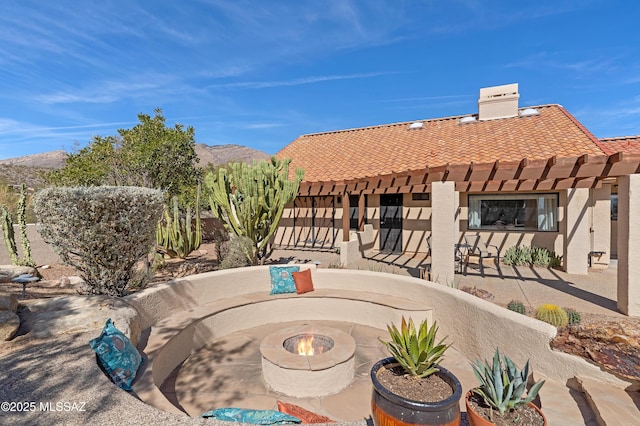 exterior space with a patio area, an outdoor fire pit, and a mountain view