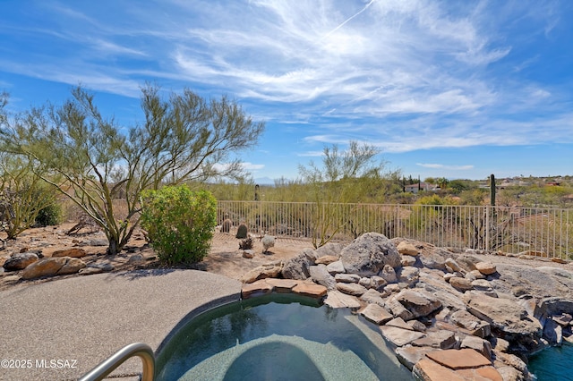 view of pool featuring a hot tub and fence