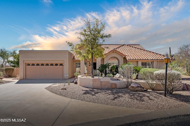 view of front of property with driveway, an attached garage, a tile roof, and stucco siding