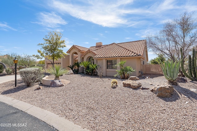 view of front of home featuring stucco siding, a chimney, fence, and a tiled roof