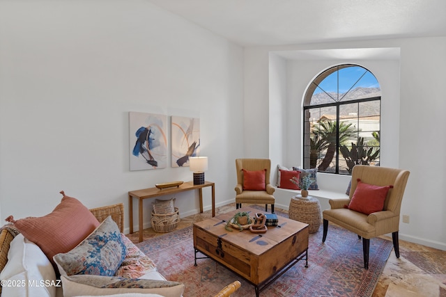 sitting room featuring stone finish flooring and baseboards