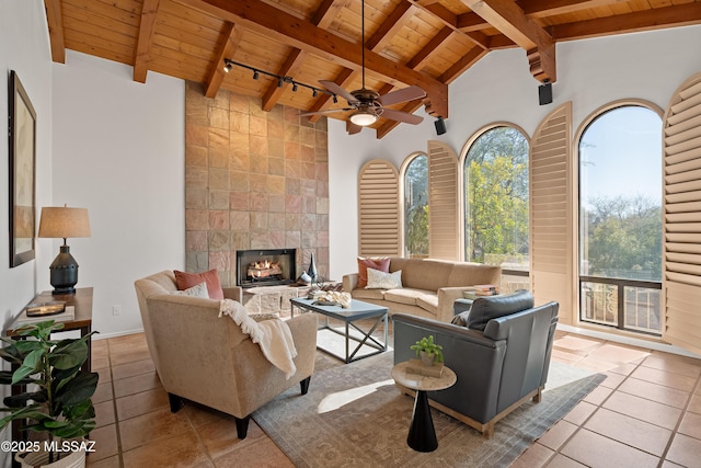 living room featuring light tile patterned floors, a tiled fireplace, lofted ceiling with beams, and wooden ceiling