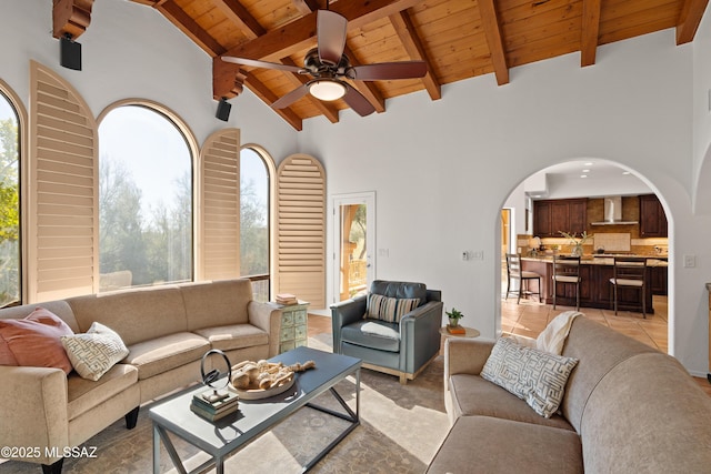 tiled living room with ceiling fan, high vaulted ceiling, beamed ceiling, and wood ceiling