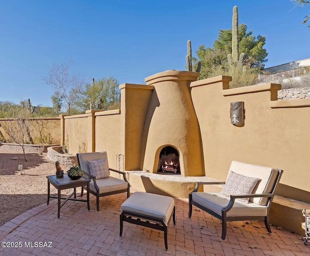 view of patio with exterior fireplace