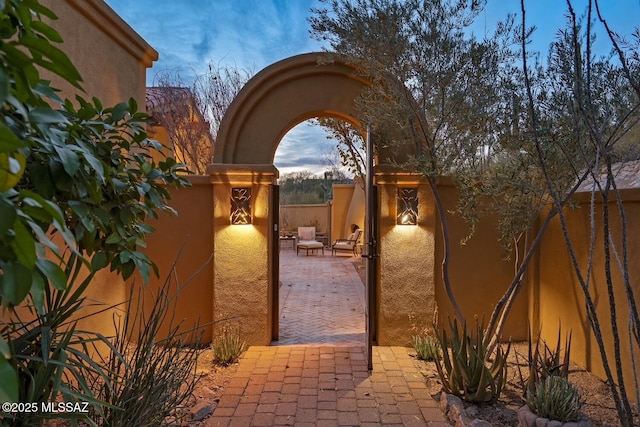 gate at dusk with a patio area