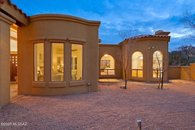 view of back house at dusk