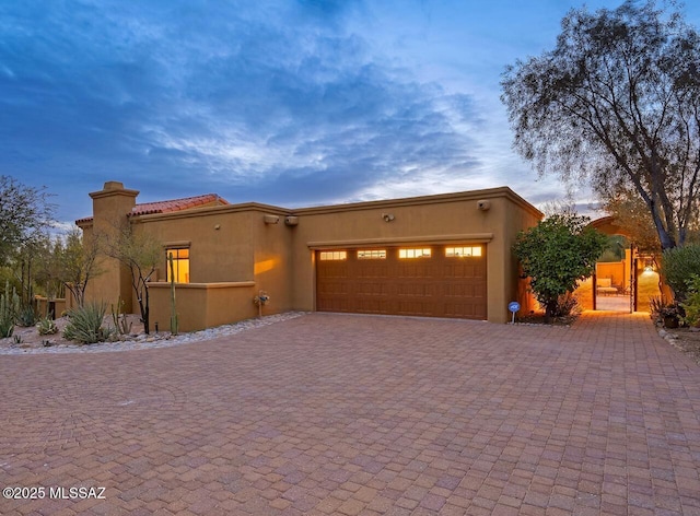 pueblo revival-style home with a garage