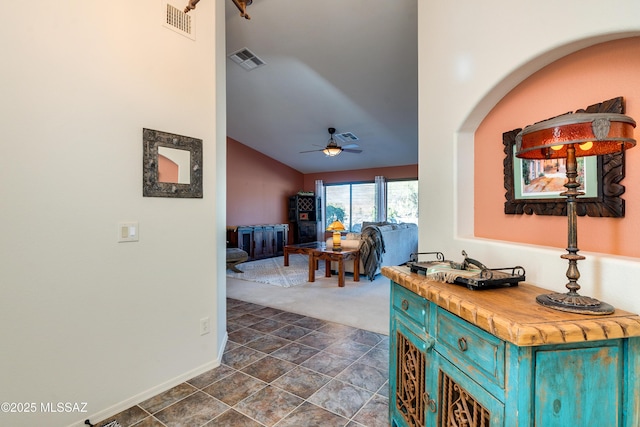 hall featuring vaulted ceiling and dark colored carpet