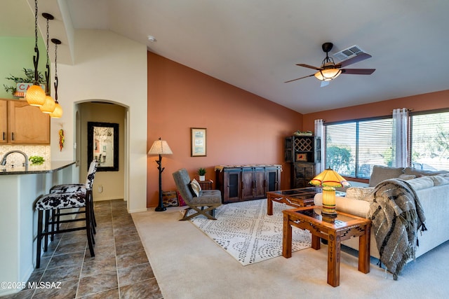 carpeted living room featuring ceiling fan, high vaulted ceiling, and sink