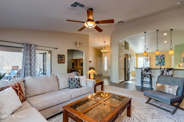 living room featuring lofted ceiling and ceiling fan with notable chandelier