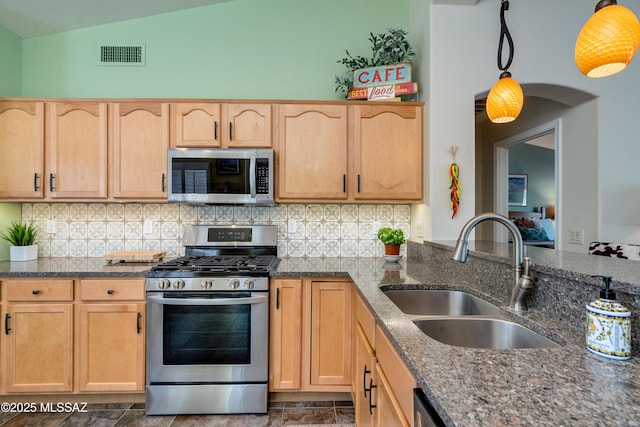 kitchen with sink, decorative light fixtures, light brown cabinets, and appliances with stainless steel finishes