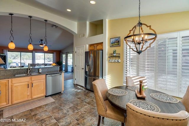 kitchen with pendant lighting, sink, lofted ceiling, stainless steel appliances, and a chandelier