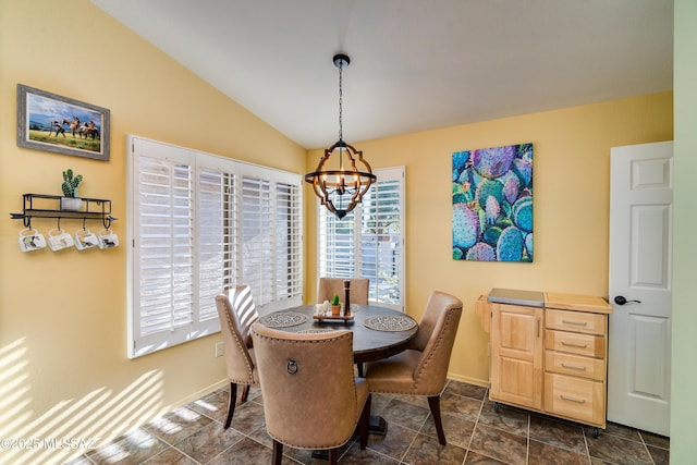 dining space featuring an inviting chandelier, lofted ceiling, and plenty of natural light