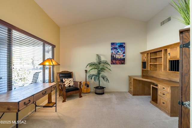 office space featuring built in desk, vaulted ceiling, and light colored carpet