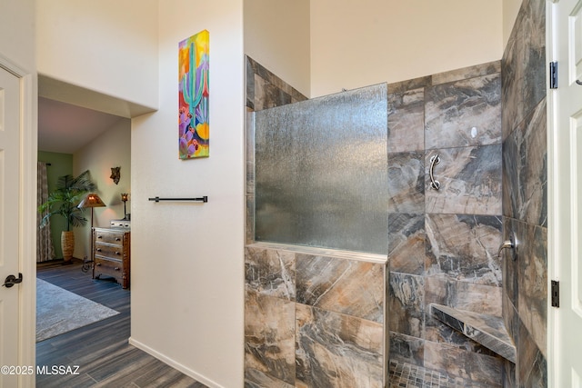 bathroom with hardwood / wood-style flooring and tiled shower