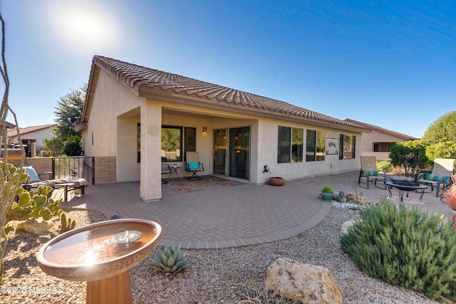 rear view of house featuring a fire pit and a patio area