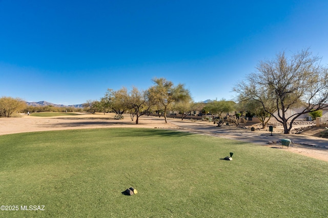 surrounding community with a mountain view and a yard