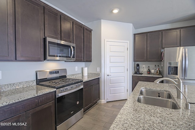 10139 N Sand Sage Trl, Marana, AZ 85653 - kitchen with stainless steel appliances, sink, dark brown cabinetry, and light stone counters