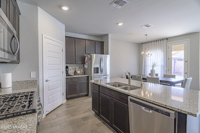 10139 N Sand Sage Trl, Marana, AZ 85653 - kitchen featuring appliances with stainless steel finishes, sink, a kitchen island with sink, and light stone counters