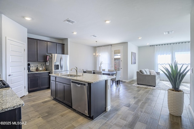 10139 N Sand Sage Trl, Marana, AZ 85653 - kitchen featuring sink, hanging light fixtures, a kitchen island with sink, light stone counters, and stainless steel appliances