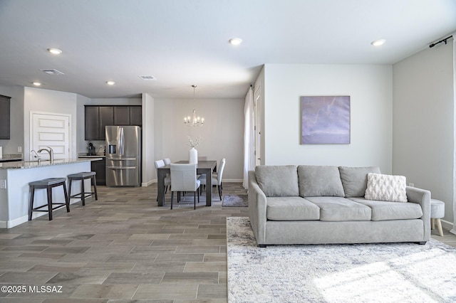 10139 N Sand Sage Trl, Marana, AZ 85653 - living room featuring sink, light hardwood / wood-style flooring, and a notable chandelier