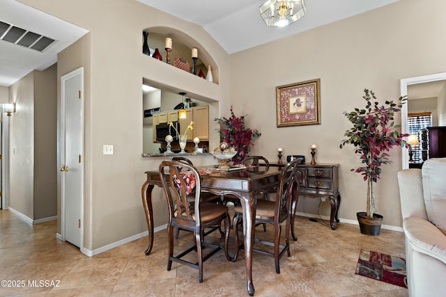 dining room with vaulted ceiling and light tile patterned floors