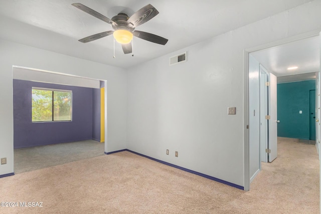 carpeted spare room featuring ceiling fan