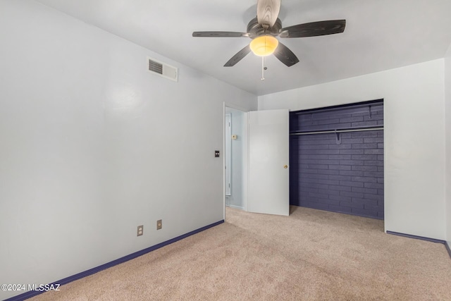 unfurnished bedroom featuring ceiling fan, light colored carpet, and a closet