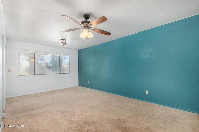 carpeted empty room featuring ceiling fan