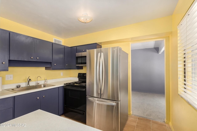 kitchen with stainless steel appliances, sink, light colored carpet, and blue cabinetry