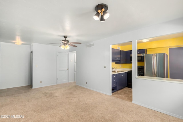 unfurnished living room with ceiling fan, light colored carpet, and sink