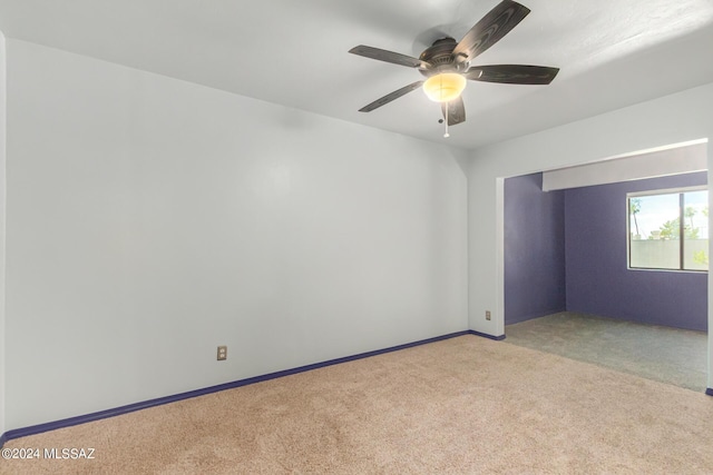 carpeted spare room with ceiling fan