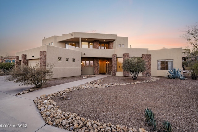 adobe home with a garage and a balcony