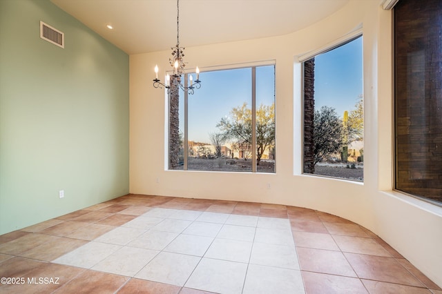 unfurnished dining area featuring a chandelier and light tile patterned flooring