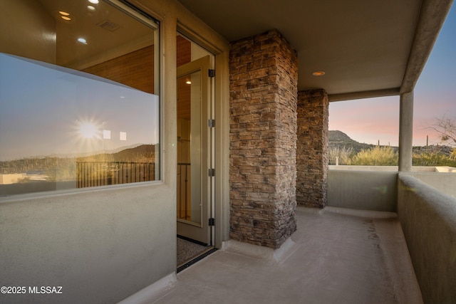 balcony at dusk featuring a mountain view