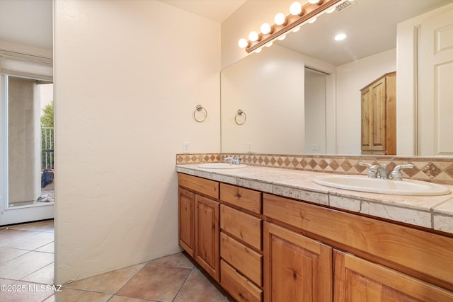 bathroom featuring tile patterned flooring, vanity, and backsplash