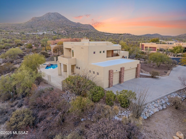 aerial view at dusk featuring a mountain view