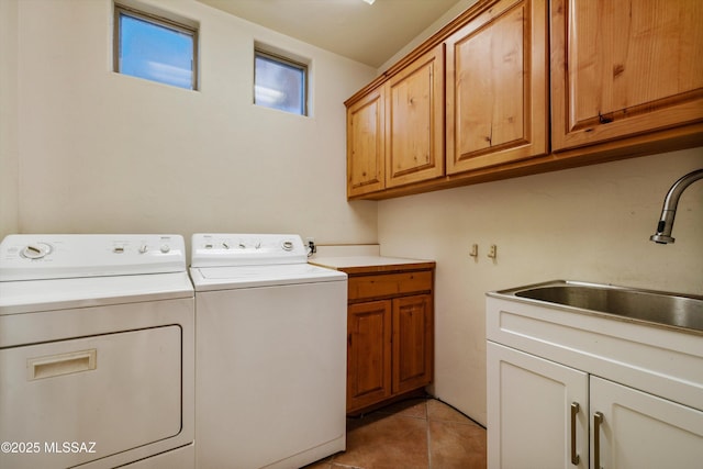 clothes washing area featuring cabinets, washing machine and dryer, sink, and light tile patterned floors