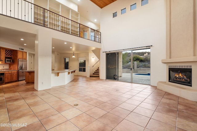 unfurnished living room with light tile patterned floors and a tile fireplace