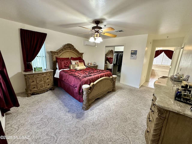 bedroom featuring a spacious closet, light colored carpet, an AC wall unit, a closet, and ceiling fan