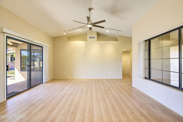 empty room with ceiling fan, track lighting, vaulted ceiling, and light wood-type flooring