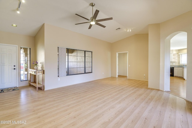 unfurnished living room with lofted ceiling, ceiling fan, and light wood-type flooring