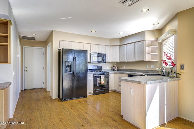 kitchen with sink, black appliances, light hardwood / wood-style flooring, kitchen peninsula, and white cabinets