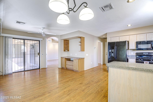 kitchen with light hardwood / wood-style flooring, light brown cabinetry, hanging light fixtures, and black appliances