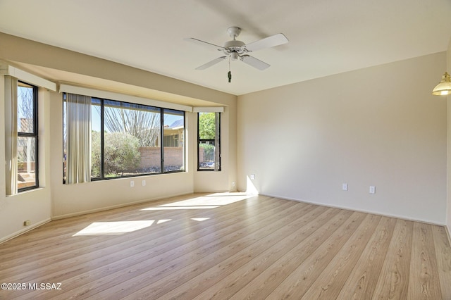 empty room with ceiling fan and light hardwood / wood-style floors