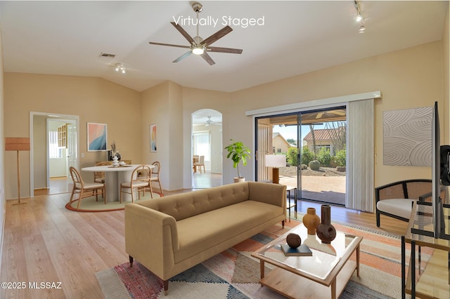 living room featuring vaulted ceiling, ceiling fan, and light hardwood / wood-style floors