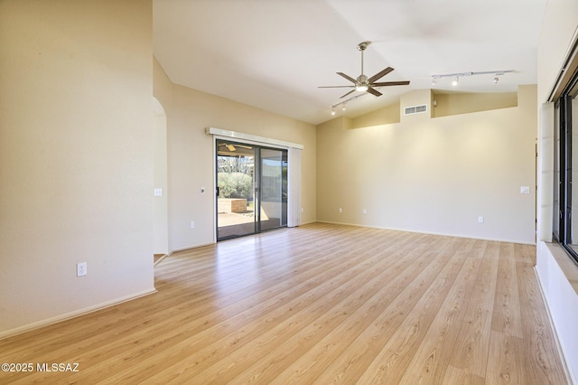 spare room featuring rail lighting, lofted ceiling, ceiling fan, and light hardwood / wood-style floors