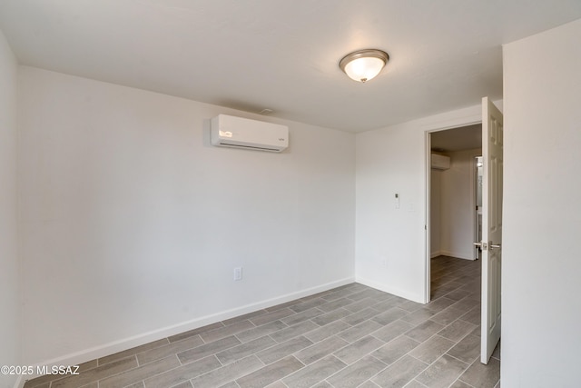 unfurnished room with an AC wall unit and light wood-type flooring